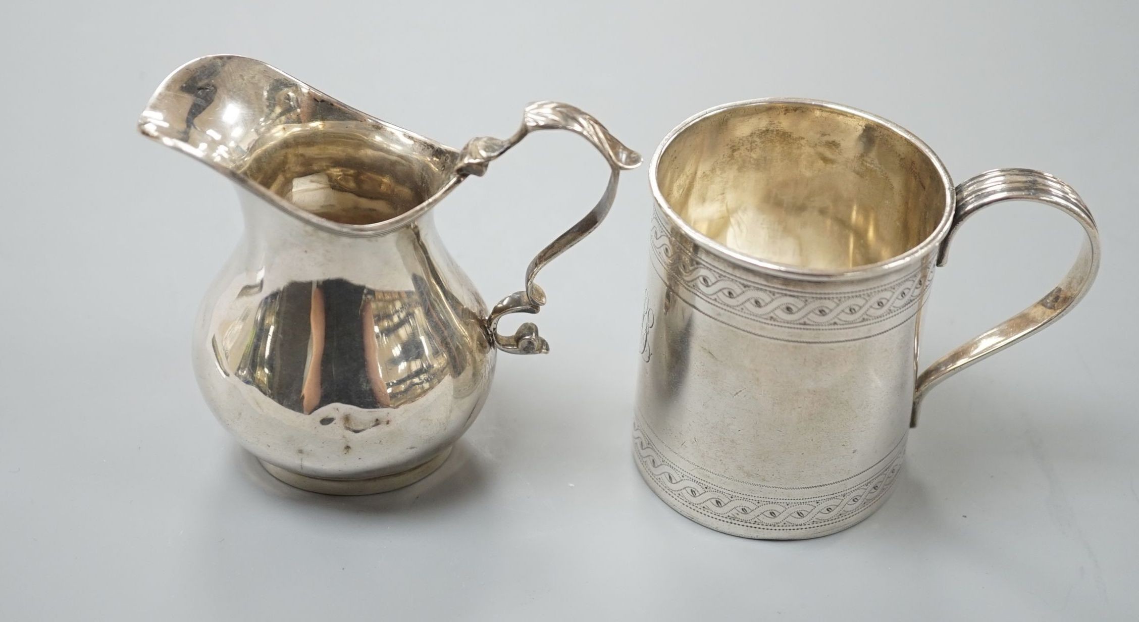 A George III engraved silver christening mug, London, 1810, 67mm and a later silver cream jug, 5oz.